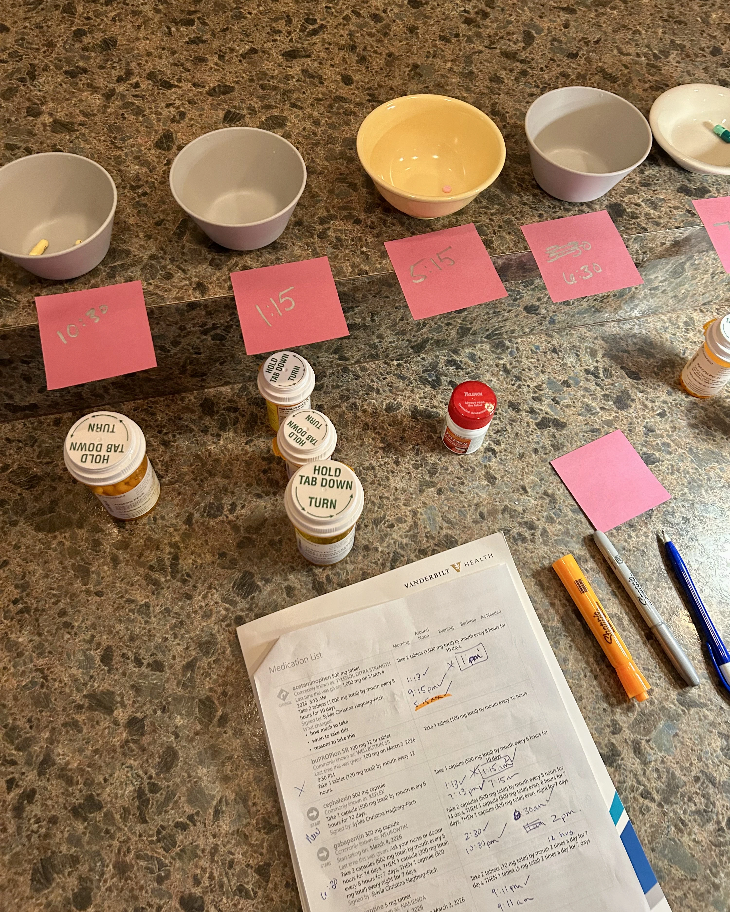 Medication bowls and pink Post-it notes from recovery